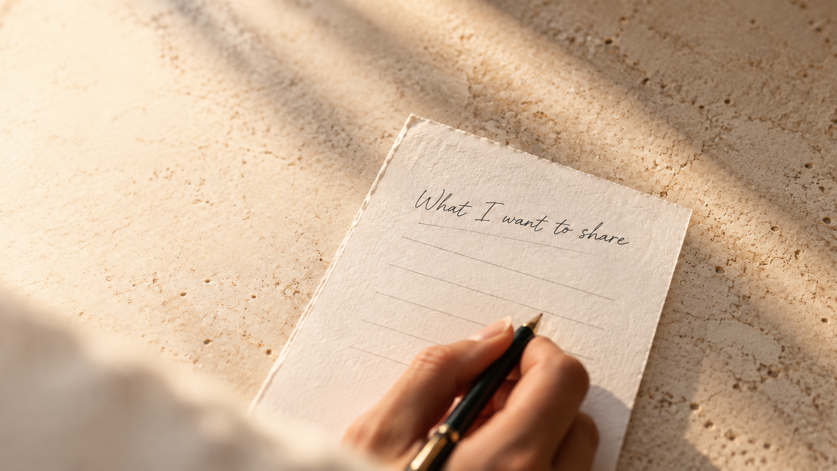 A hand preparing a personal note on tactile paper in warm sunlight